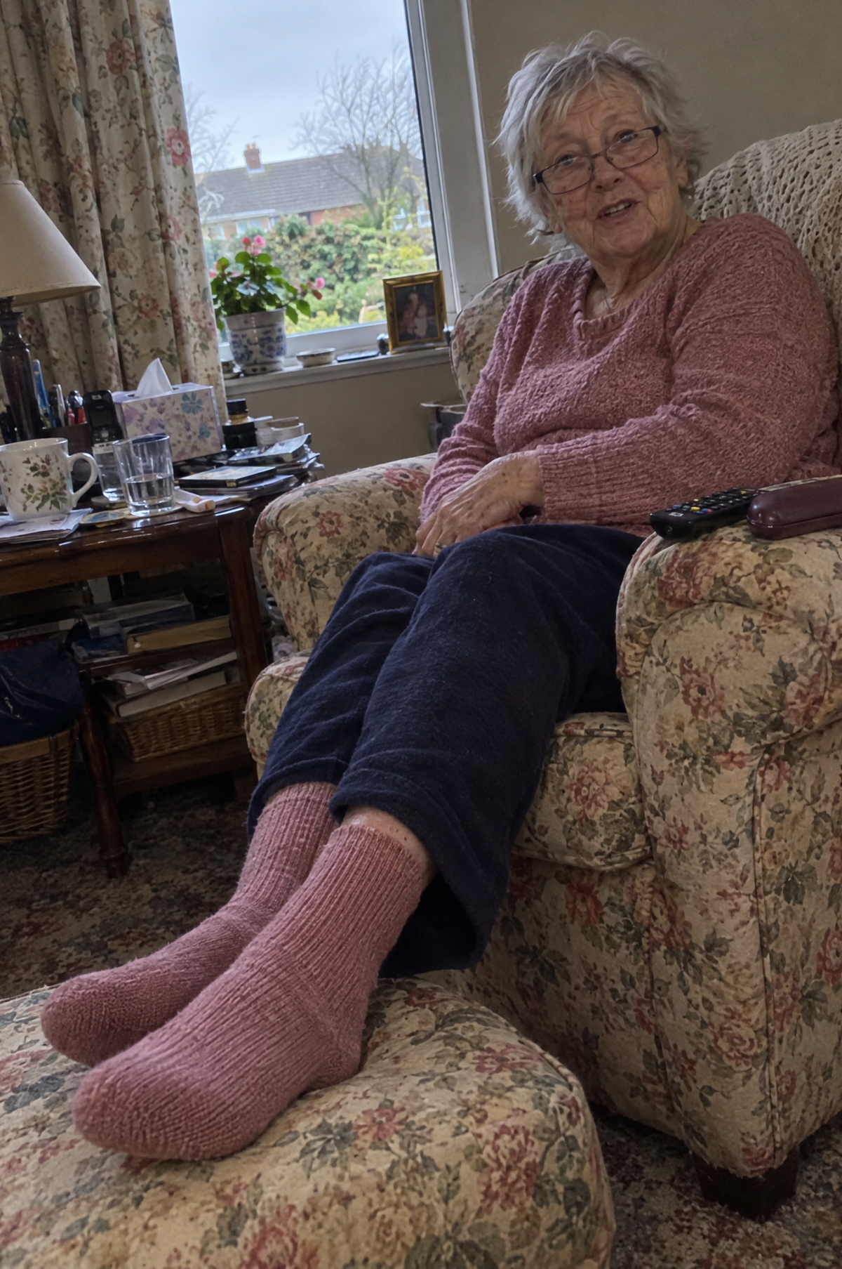 Woman in her armchair with her feet up in dusty rose HugStep socks